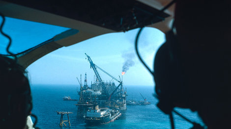 View of marine oil rig and tankers from helicopter cockpit