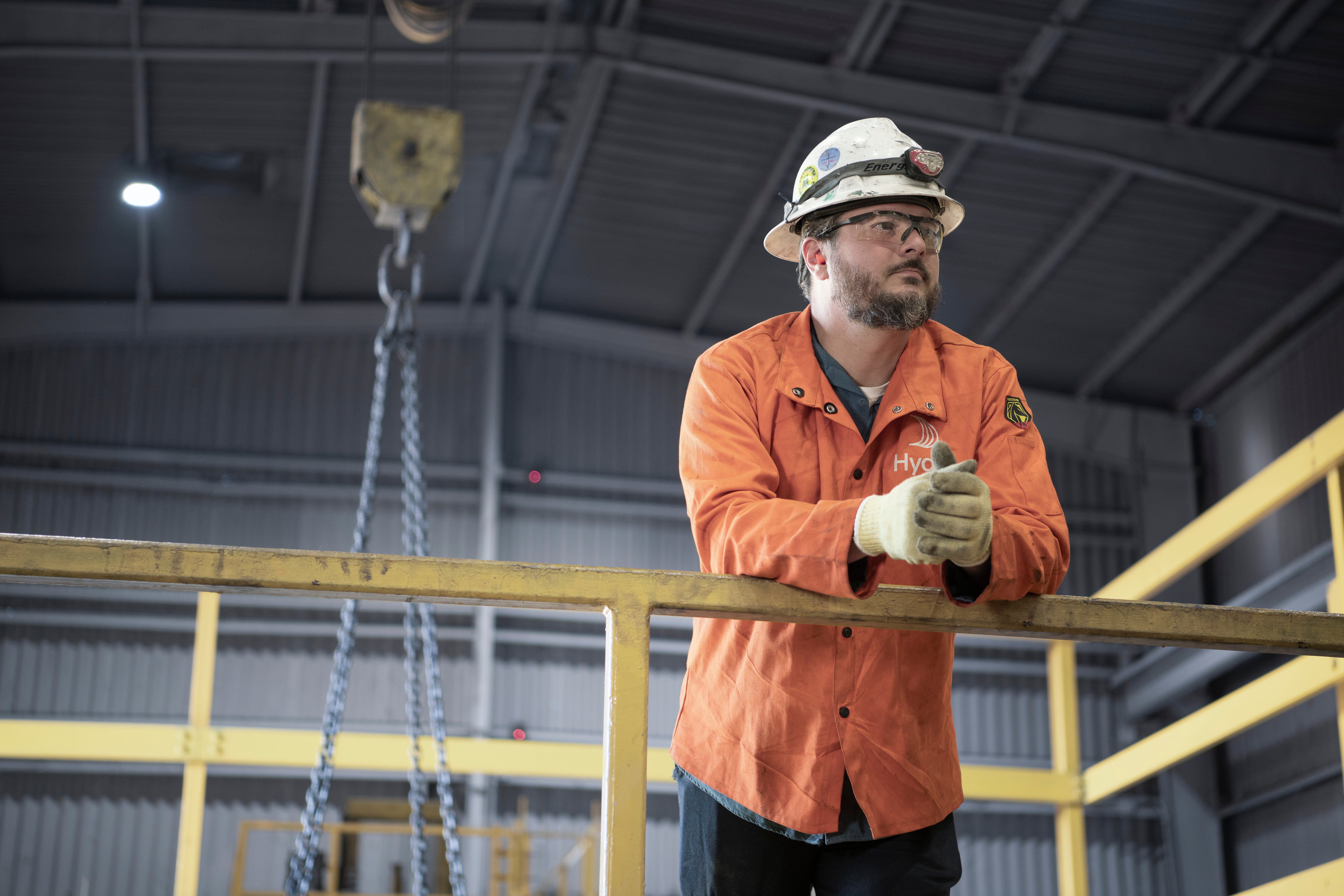 A Hydro employee wearing a safety helmet leaning to a handrail at Hydro Phoenix