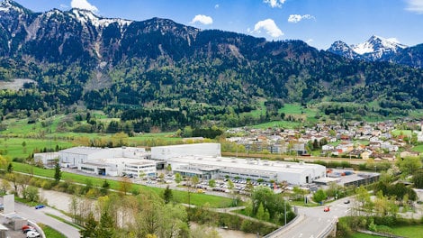 a large building with a road and mountains in the background