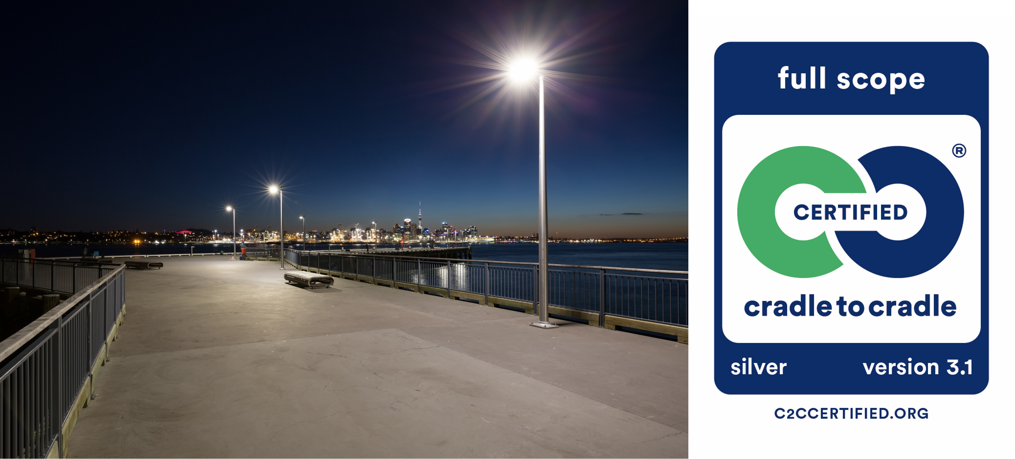 a walkway with a railing and a body of water with a city in the background