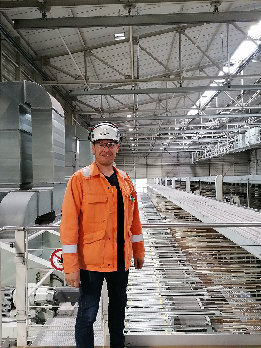 a man wearing a hard hat and standing in a warehouse