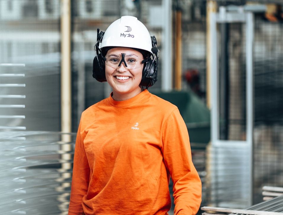 a woman wearing a white hard hat and earphones