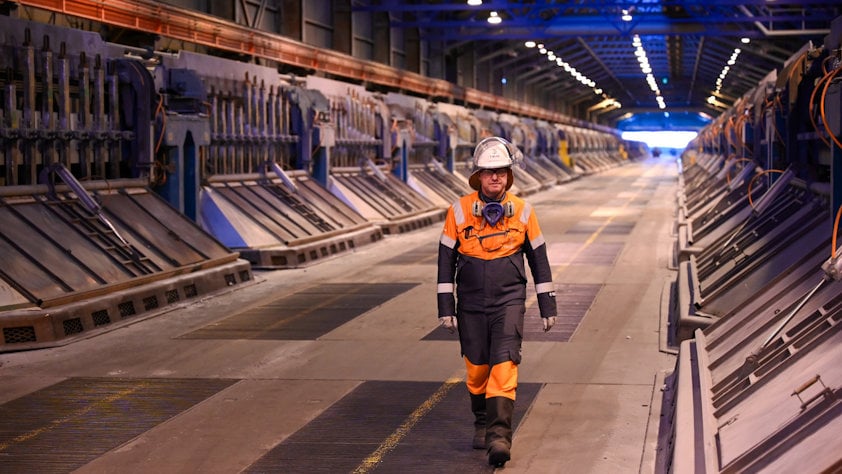 a person wearing a helmet and standing in a large factory hall