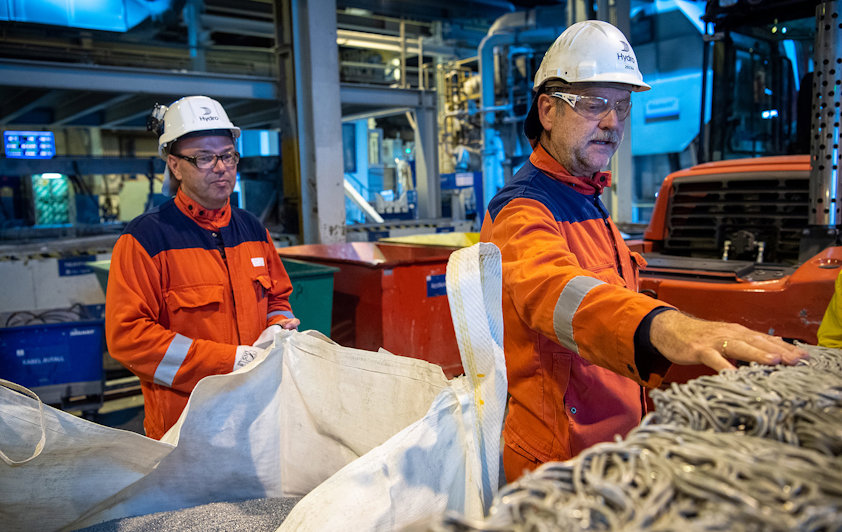 Fabrikksjef Arne-Martin Kjærland (t.v) og Helge Vadheim viser fram gamle kraftledninger som skal bli resirkulert og brukt i aluminiumproduksjon i Høyanger