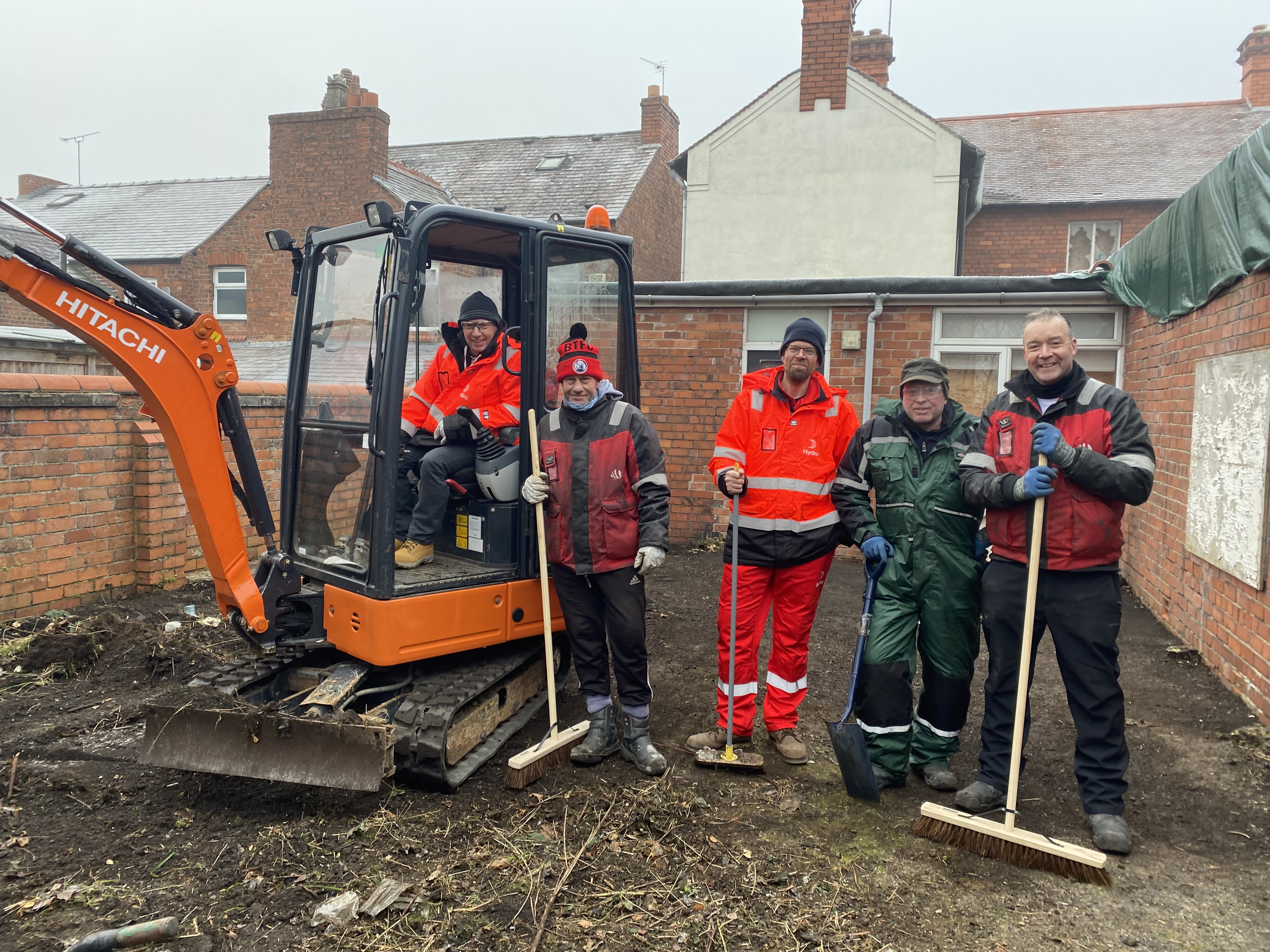 a group of men standing next to a bulldozer
