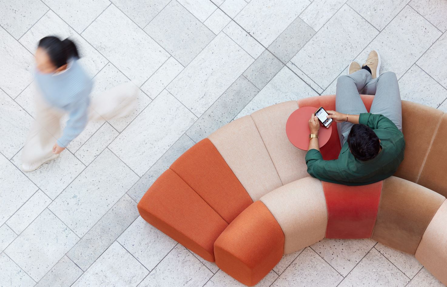 a man and woman sitting on a couch looking at a cell phone