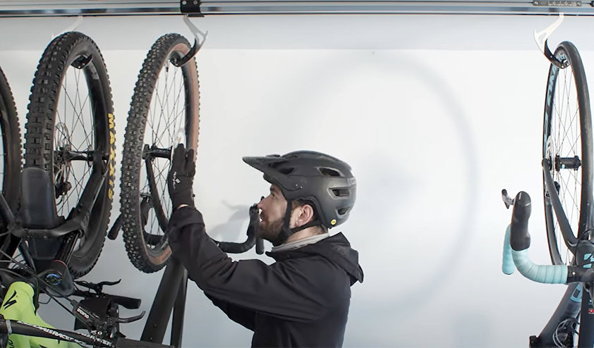 a person wearing a helmet and holding a bicycle