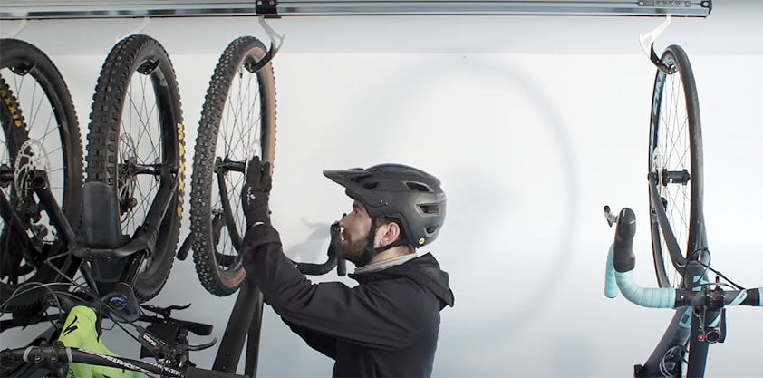 a person wearing a helmet and holding a bicycle