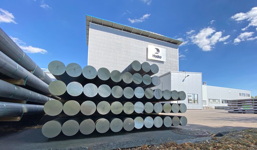 a large building with a large stack of aluminium ingots in front of it