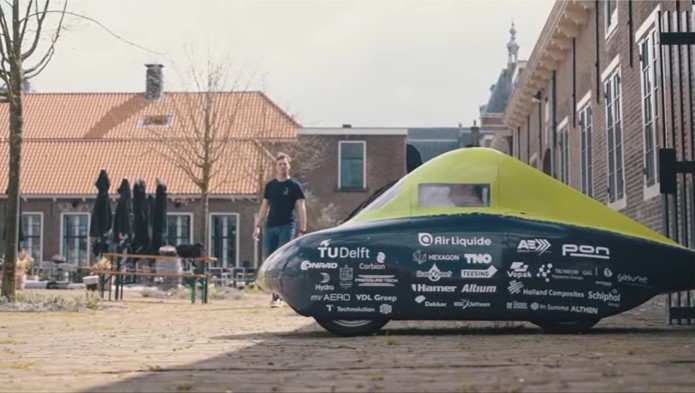 a person standing next to a green trampoline
