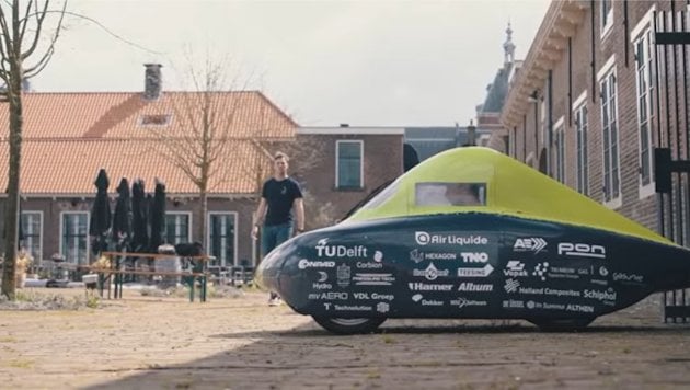 a person standing next to a green trampoline