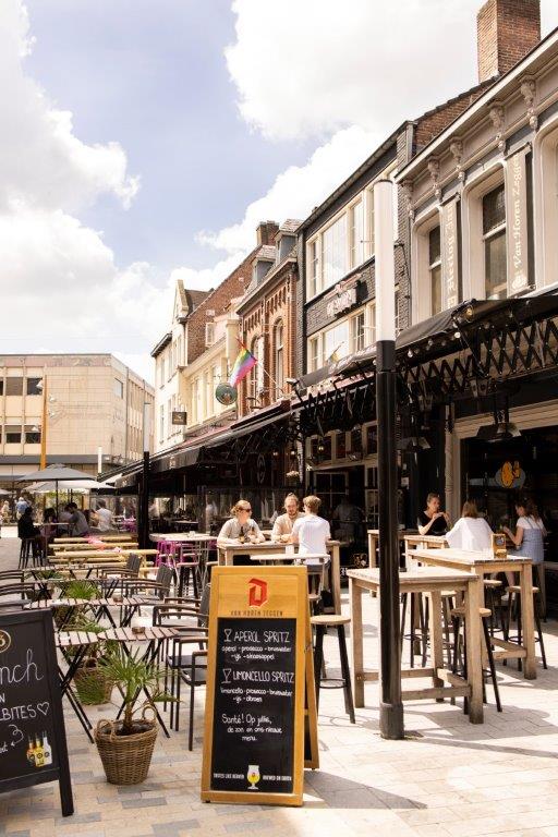 a group of people sitting at tables outside of a building
