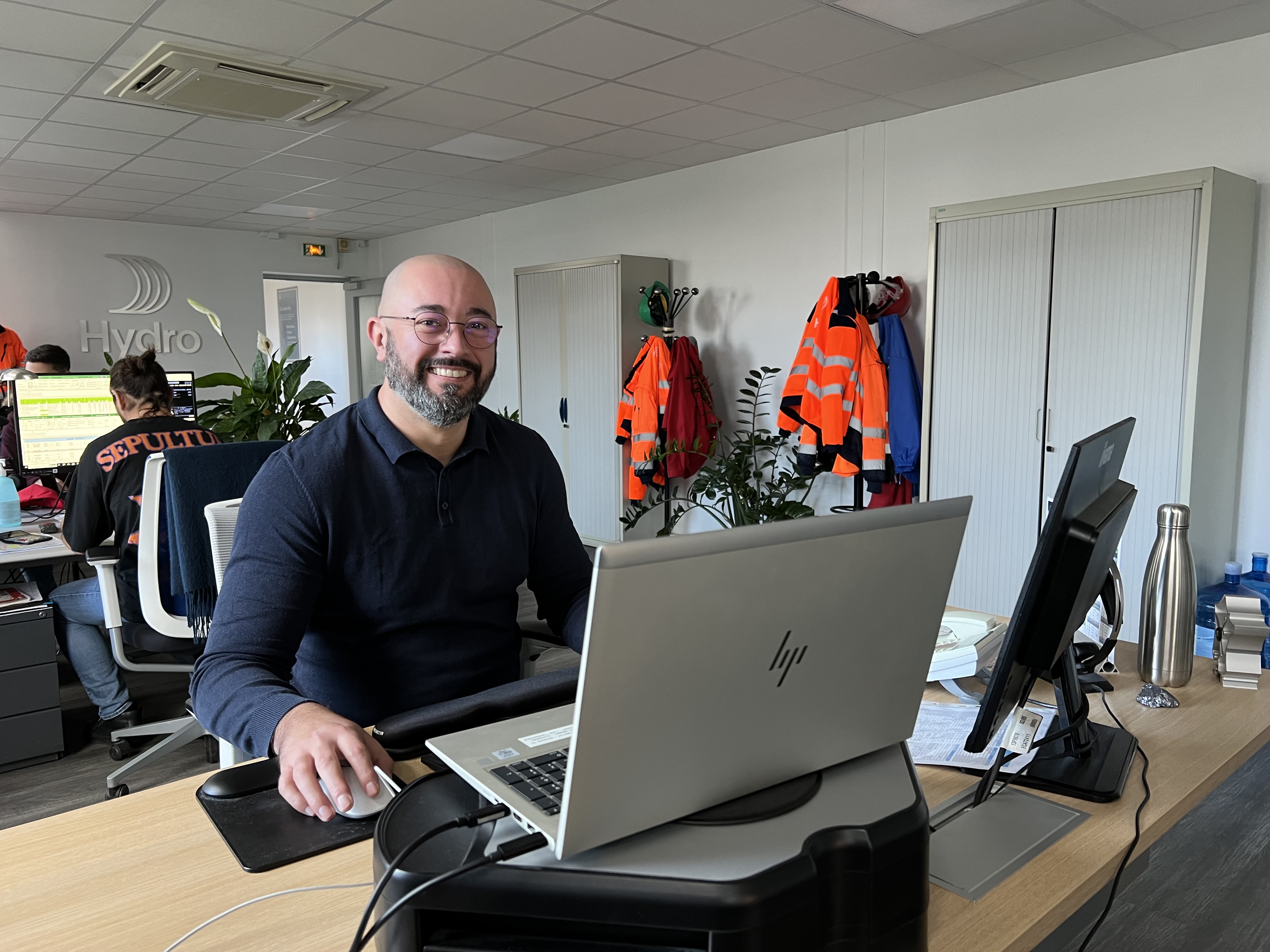 a person sitting at a desk with a laptop