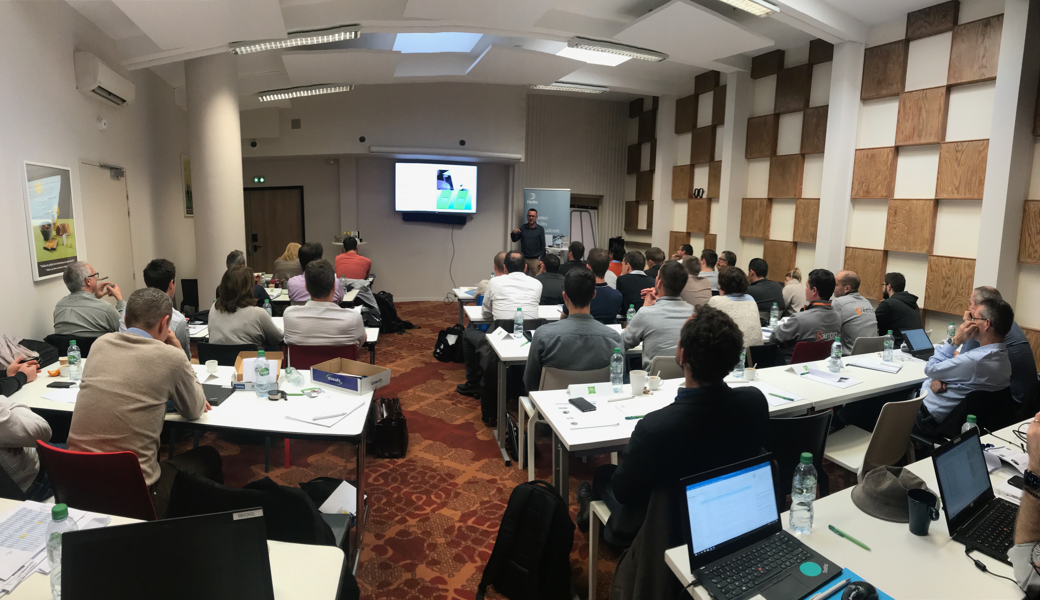 a group of people sitting at tables in a conference room
