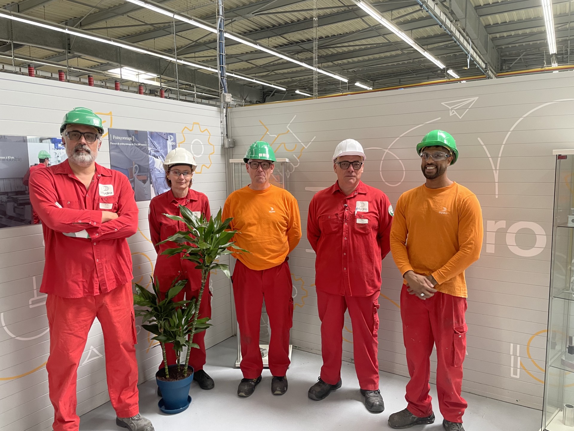 a group of men in red jumpsuits standing in front of a glass wall