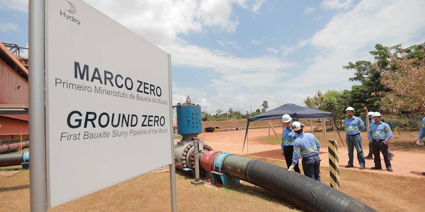 a group of people wearing hardhats and standing next to a sign