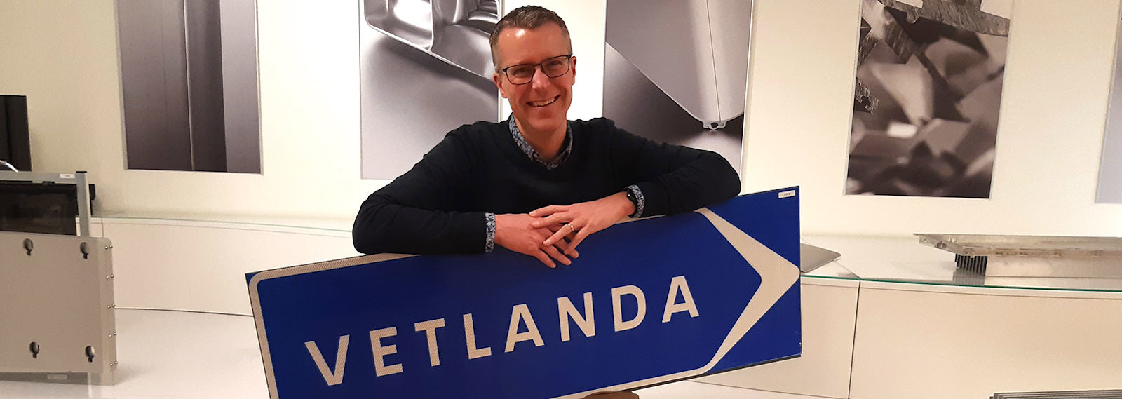 Hans Fredriksson is posing with a Vetlanda sign