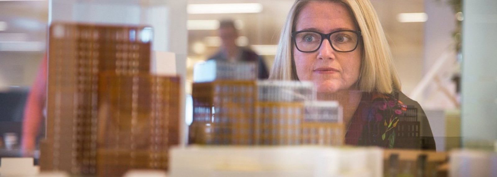 Unni Hofstad behind a scale model of office buildings