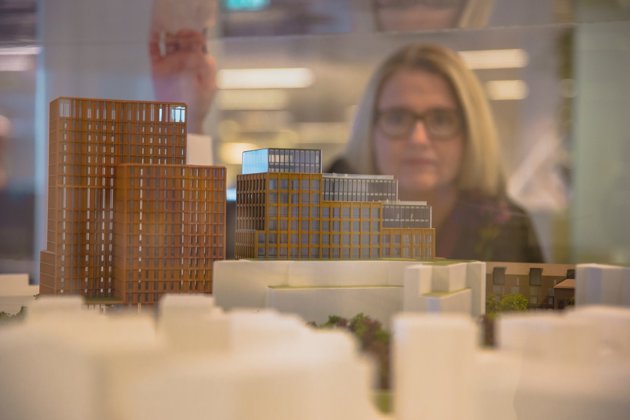 Unn Hofstad with a scale model of office buildings
