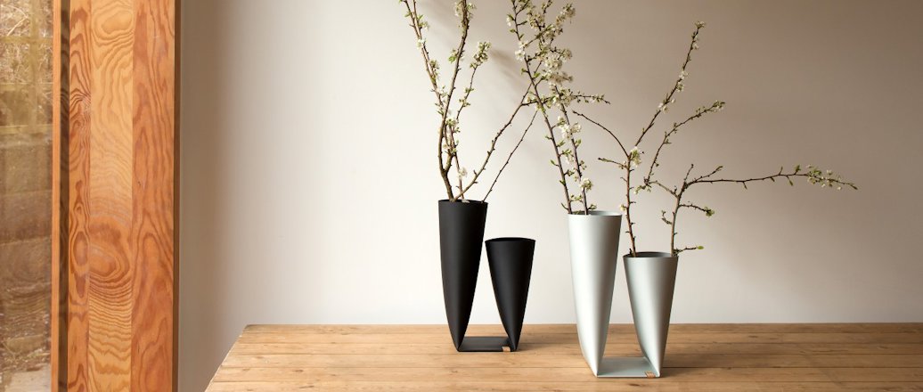 schwarze und weiße Vasen aus Aluminium auf einem Tisch