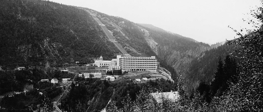 a black and white photo of a town in the mountains