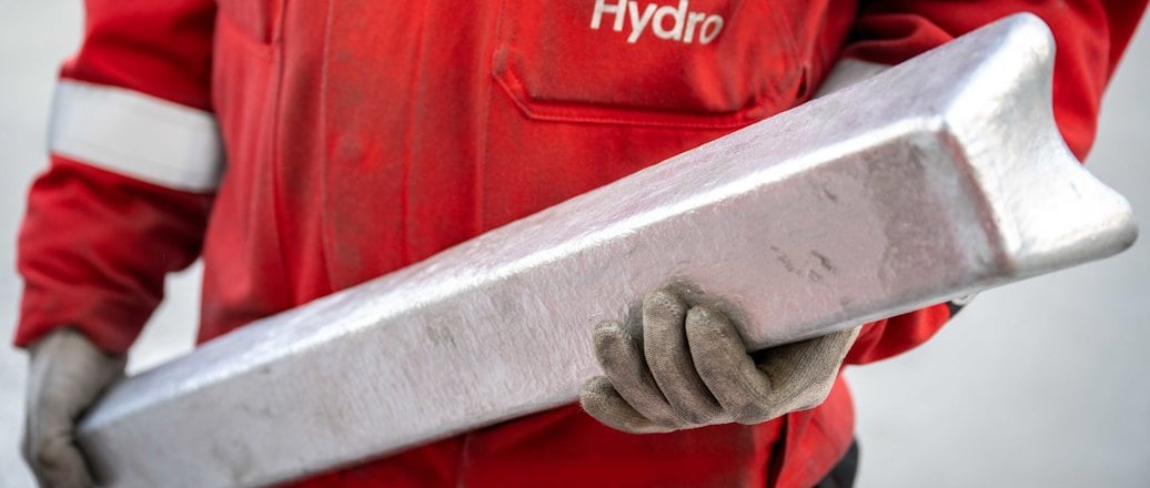 Worker holding aluminium ingot Worker holding aluminium ingot