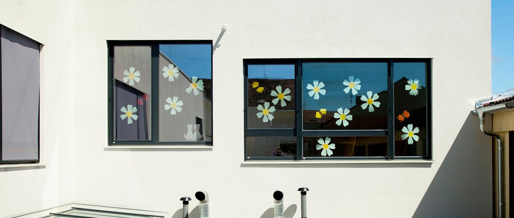 exterior windows, decorated with paper flowers, above a roof exterior windows, decorated with paper flowers, above a roof