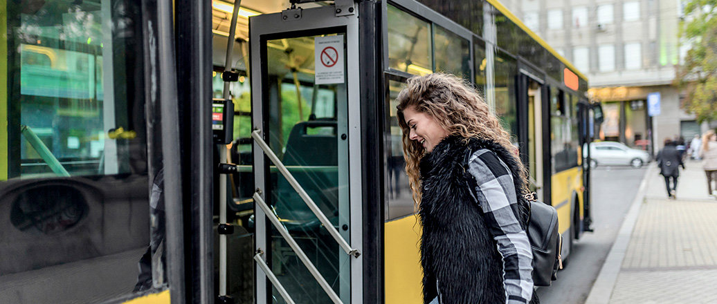 Young woman stepping into the bus Young woman stepping into the bus