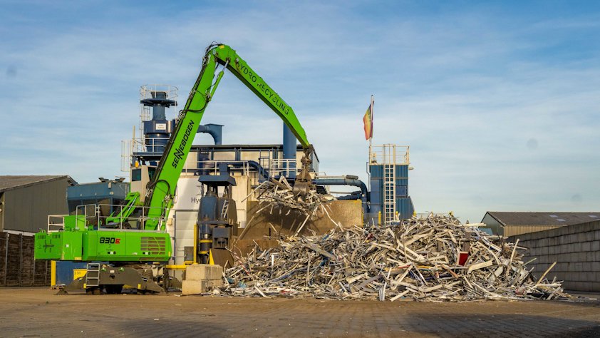 A crane lifting a pile of aluminium scrap A crane lifting a pile of aluminium scrap